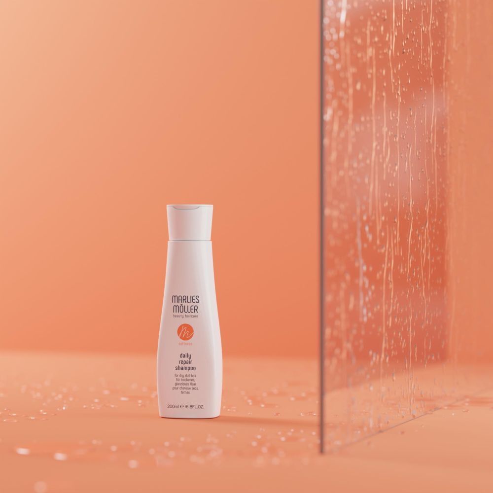Weiße Shampoo-Flasche vor orangefarbenem Hintergrund. Aufschrift: Marlies Müller, daily repair shampoo. 200ml/6.8FL.OZ.