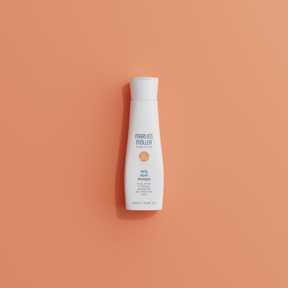 Weiße Shampoo-Flasche auf orangefarbenem Hintergrund. Aufschrift: Marlies Müller, daily repair shampoo. 200ml/6.8FL.OZ.