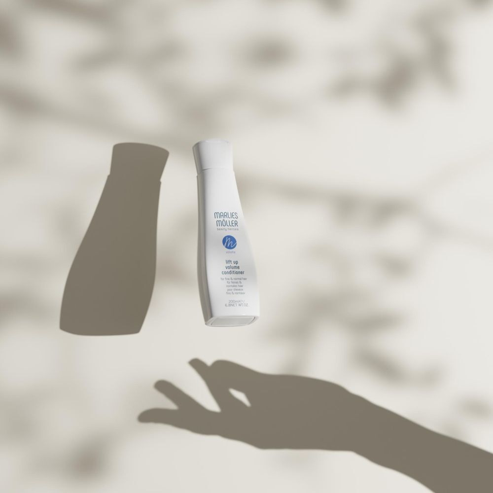 Marlies Möller Volume Conditioner Flasche und Schatten auf hellem Hintergrund. Hand-Schatten.