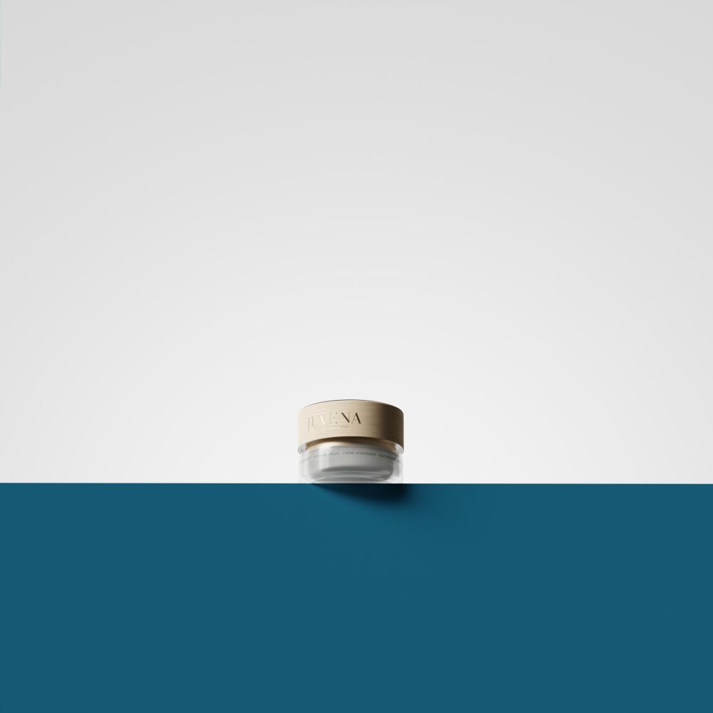 Creme-Tiegel mit goldfarbenem Deckel. Auf weißem und blauem Hintergrund.