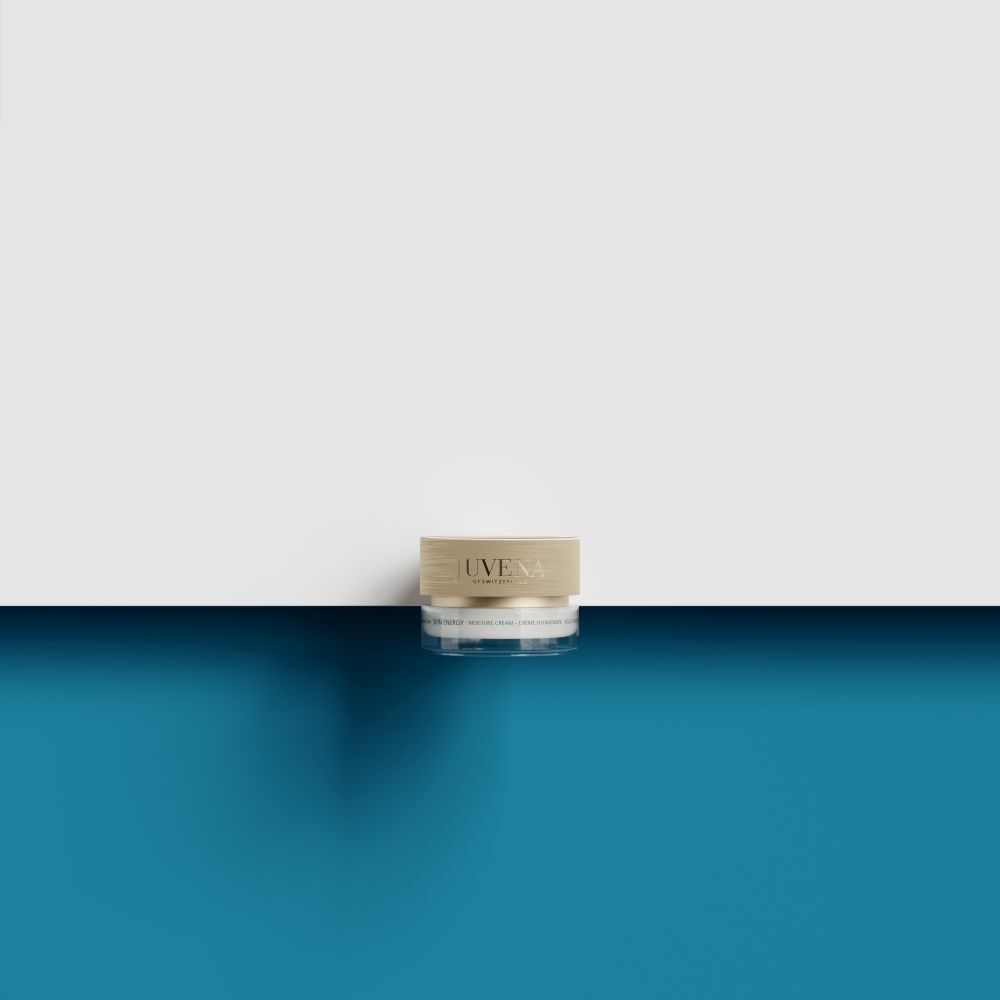 Creme-Tiegel mit goldfarbenem Deckel. Auf weißem und blauem Hintergrund.