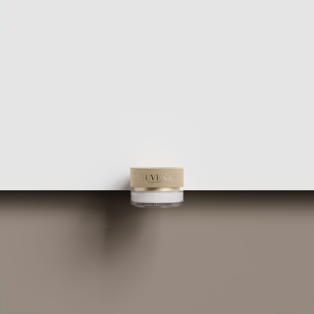 Creme-Glas mit goldfarbenem Deckel. Auf brauner Oberfläche. Weißer Hintergrund.