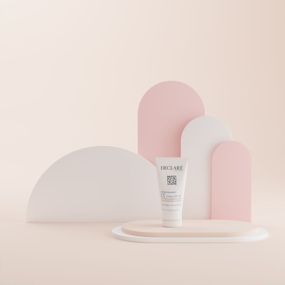 Tube DECLARÉ CC Cream SPF 30 auf einem Podest. Hintergrund mit rosa und weißen Formen.
