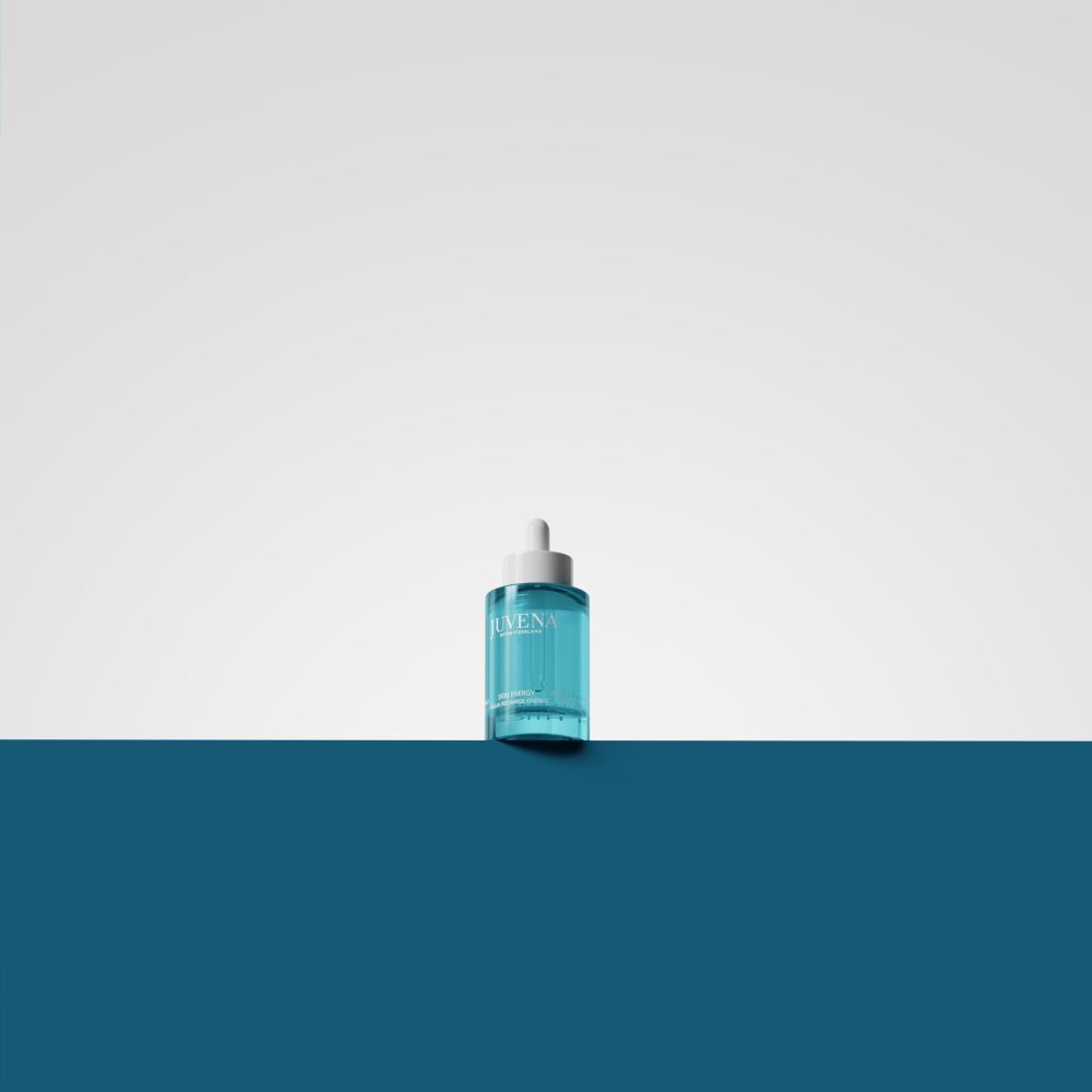 Türkisgrüne Flasche mit weißem Deckel und Pipette. Auf weißem und blauem Hintergrund.