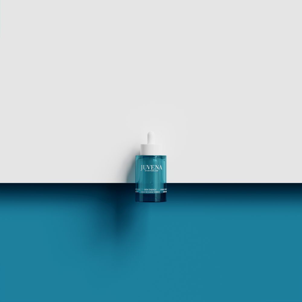 Türkisgrüne Flasche mit weißem Deckel und Pipette. Auf weißem und blauem Hintergrund.