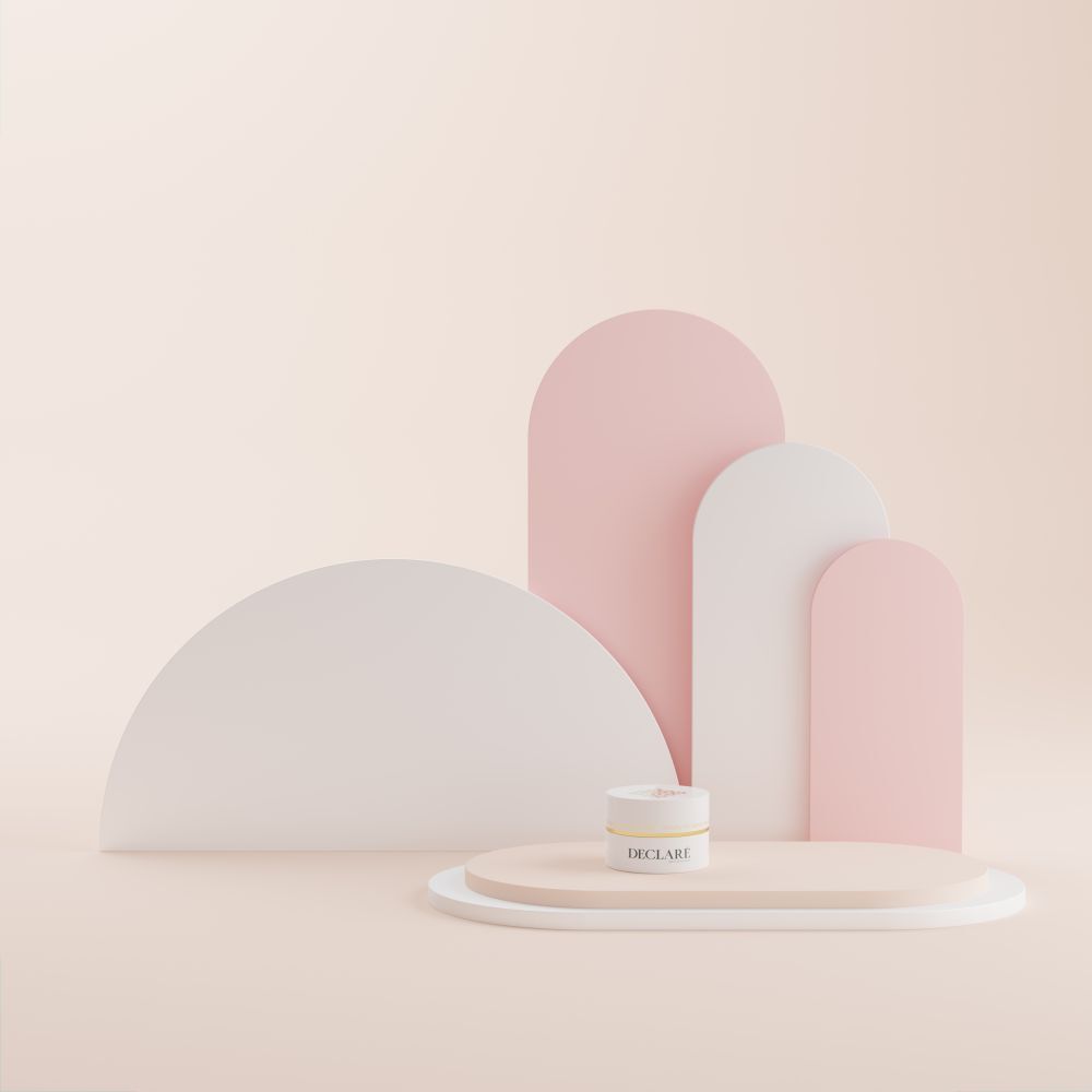 Weißer Tiegel auf einem Podest. Hintergrund mit rosa und weißen Formen. DECLARÉ-Logo sichtbar.