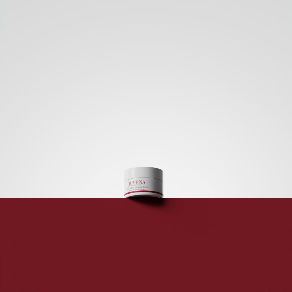 Creme-Tiegel auf rotem und weißem Hintergrund. Aufschrift: JUVENA, REJUVEN® Superior Care. Weißer Deckel, roter Streifen.