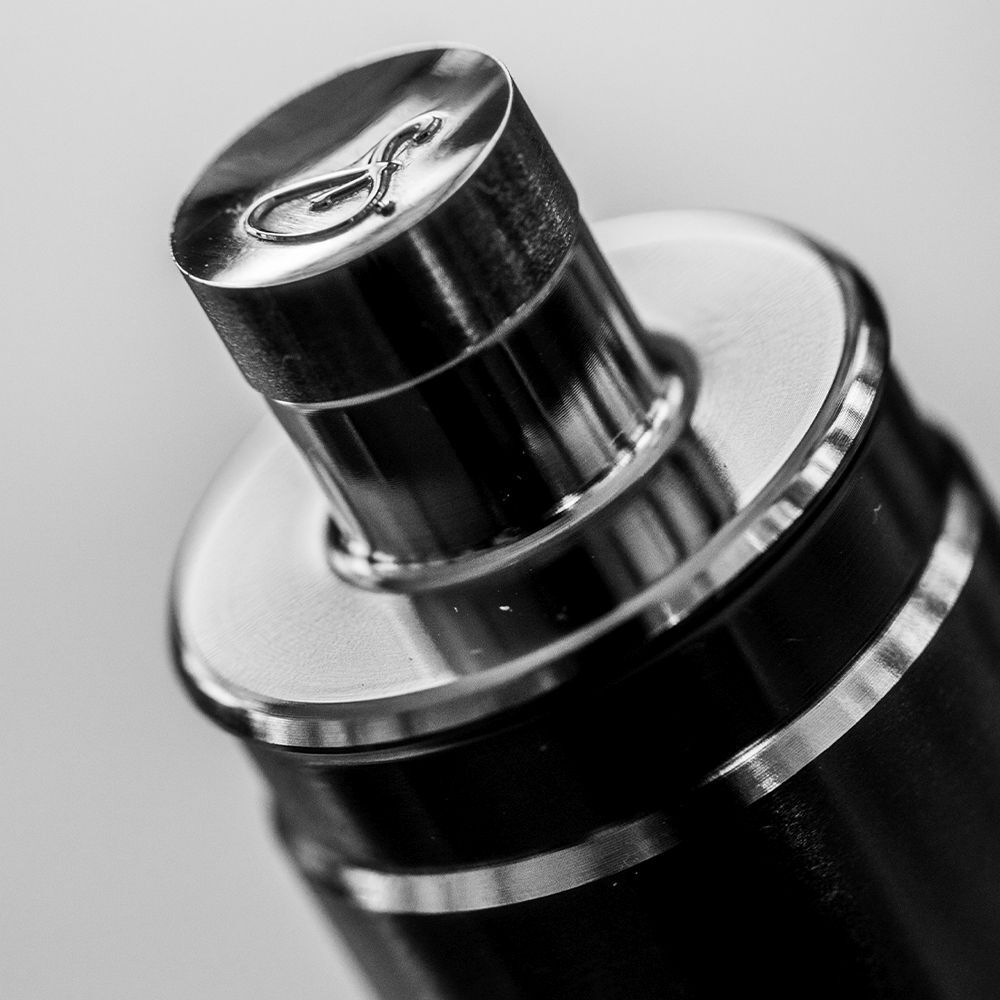 Nahaufnahme des Deckels einer Flasche. Metallisch glänzend mit eingraviertem Logo.