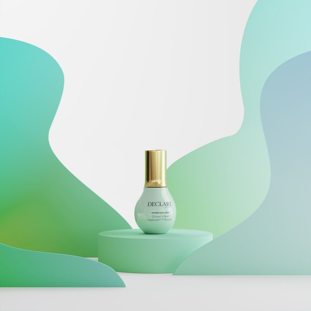 Produkt auf mintgrüner Säule. Hintergrund mit grünen und blauen Formen. Aufschrift: DECLARÉ, Ocean's Best Hyaluron triple Booster.
