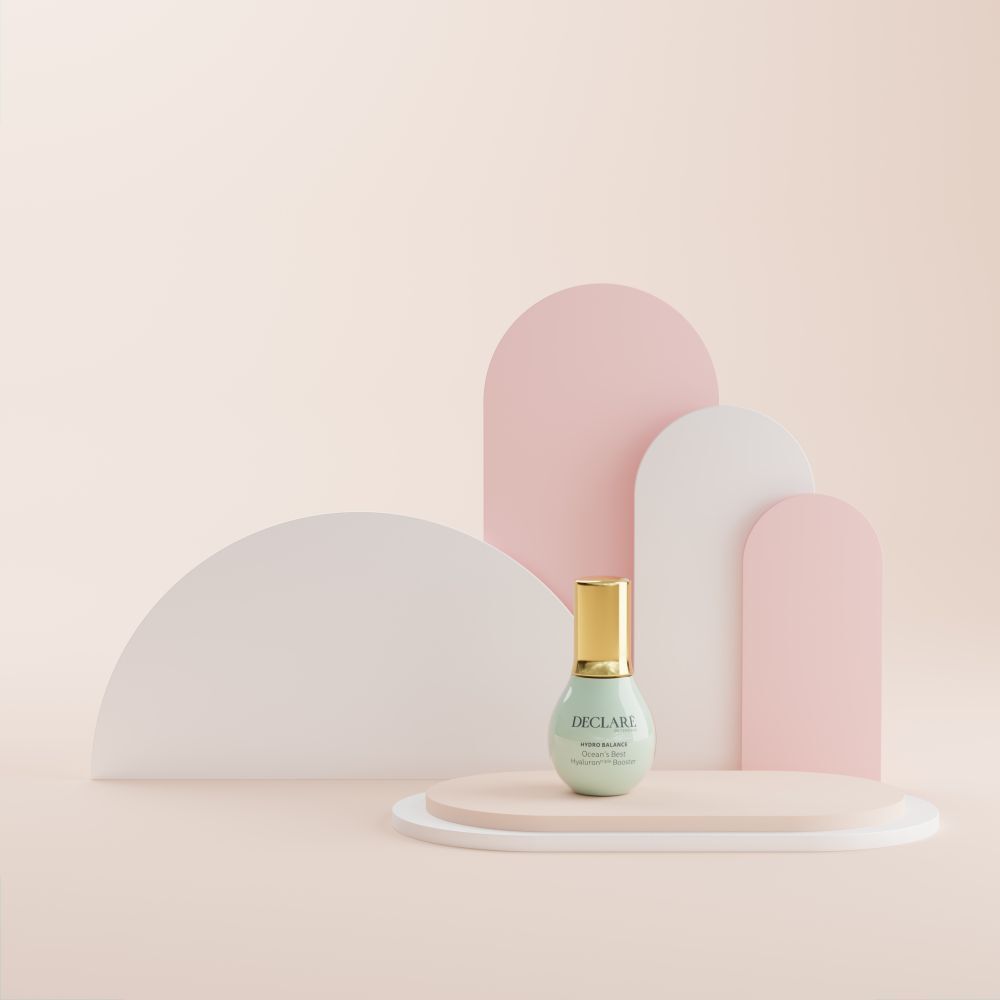 Flasche auf einem Podest. Hintergrund: rosa, weiß und rosa Formen. Aufschrift: DECLARÉ, Ocean's Best Hyaluron triple Booster.