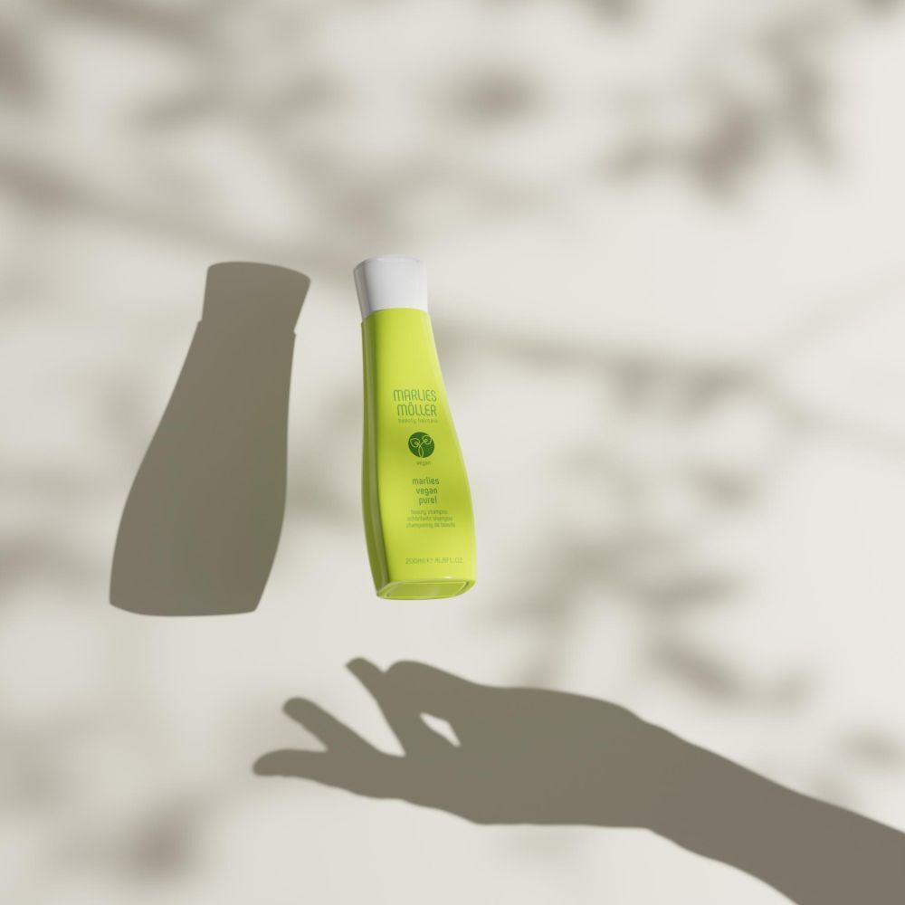 Grüne Shampoo-Flasche und Schatten. Aufschrift: Marlies Möller, Vegan Pure! Beauty Shampoo.