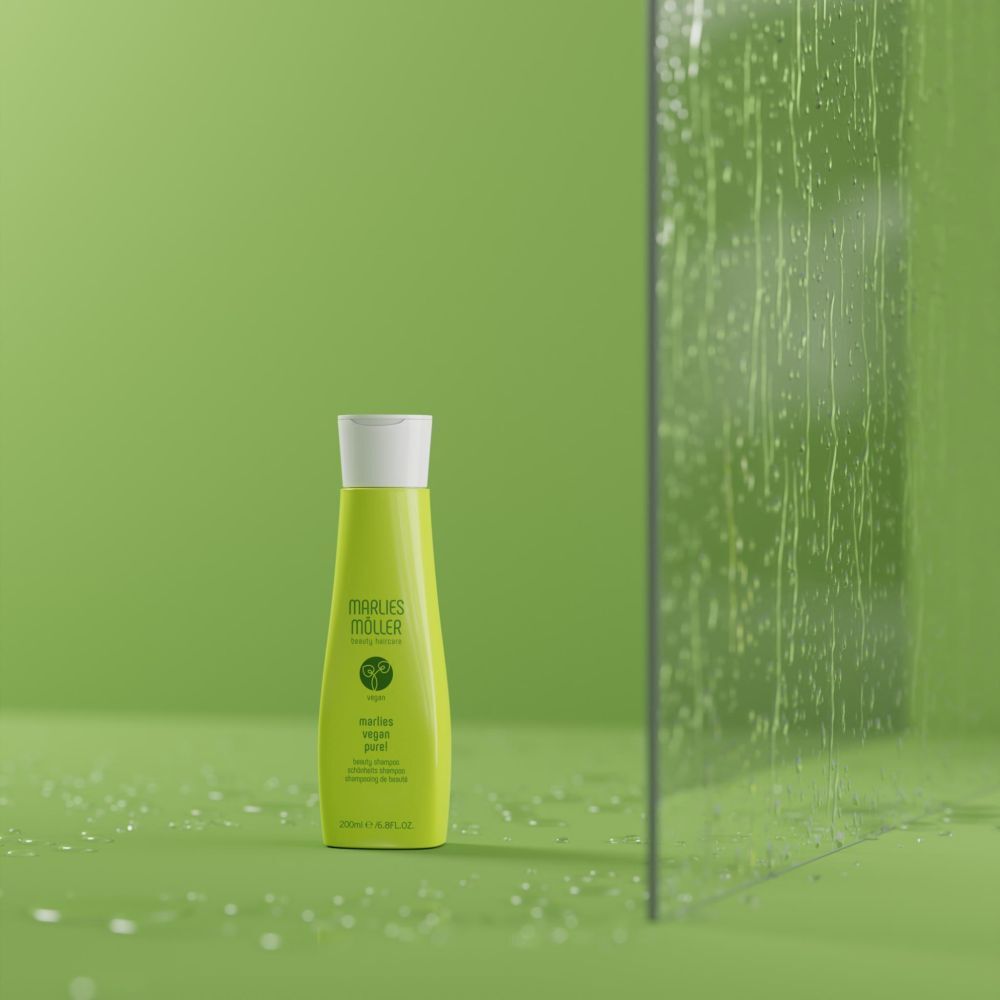 Grüne Shampoo-Flasche vor grünem Hintergrund und Glaswand. Aufschrift: Marlies Möller, Vegan Pure!