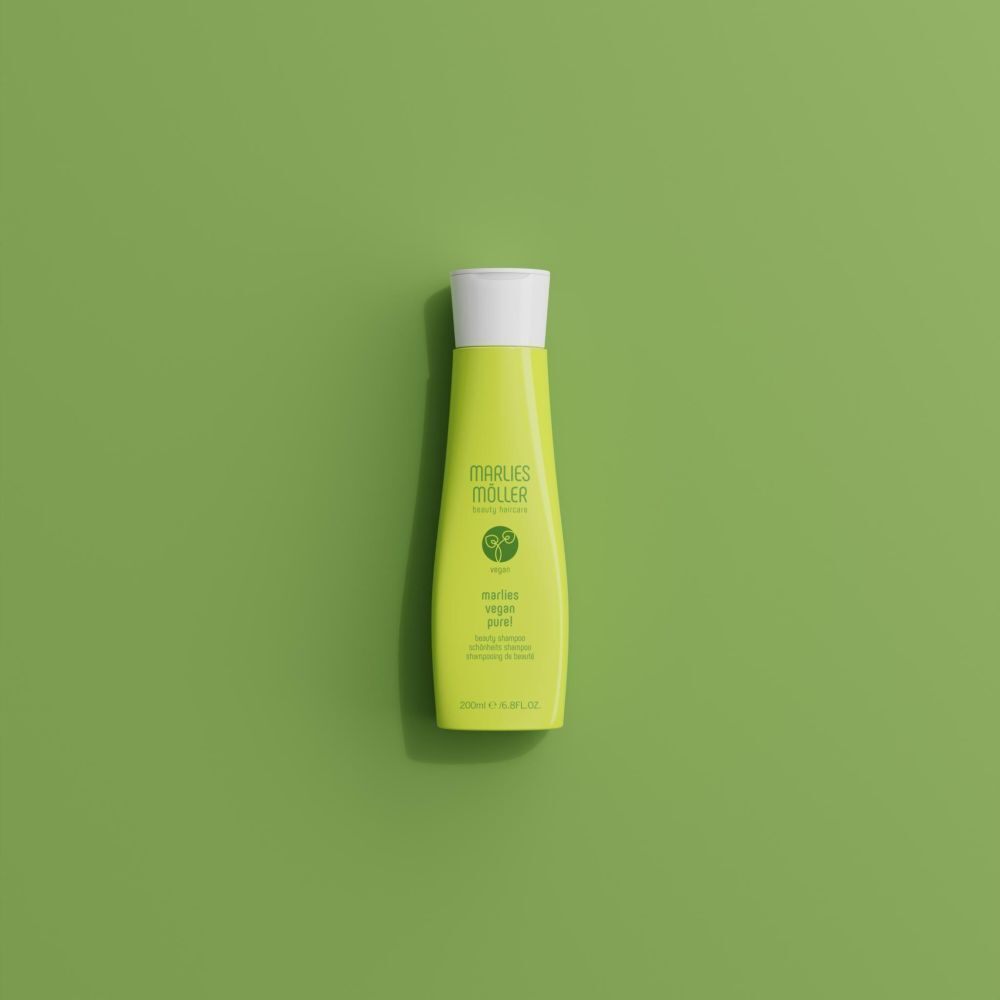 Grüne Shampoo-Flasche auf grünem Hintergrund. Aufschrift: Marlies Möller, Vegan Pure! Beauty Shampoo.