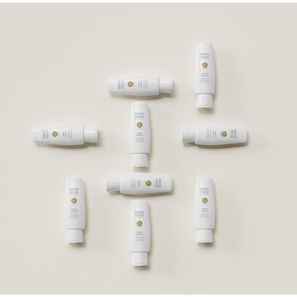 Mehrere weiße Flaschen Marlies Möller Keratin Cream Oil. Produktname, Logo und Schriftzug. Glatt & glänzend.