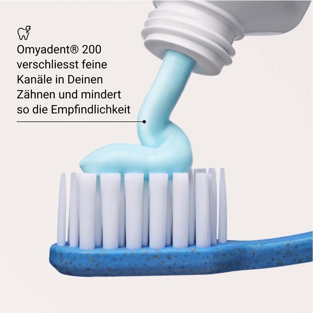 Zahnpasta wird auf eine Zahnbürste gedrückt. Text: Omyadent® 200 verschließt feine Kanäle in Deinen Zähnen.