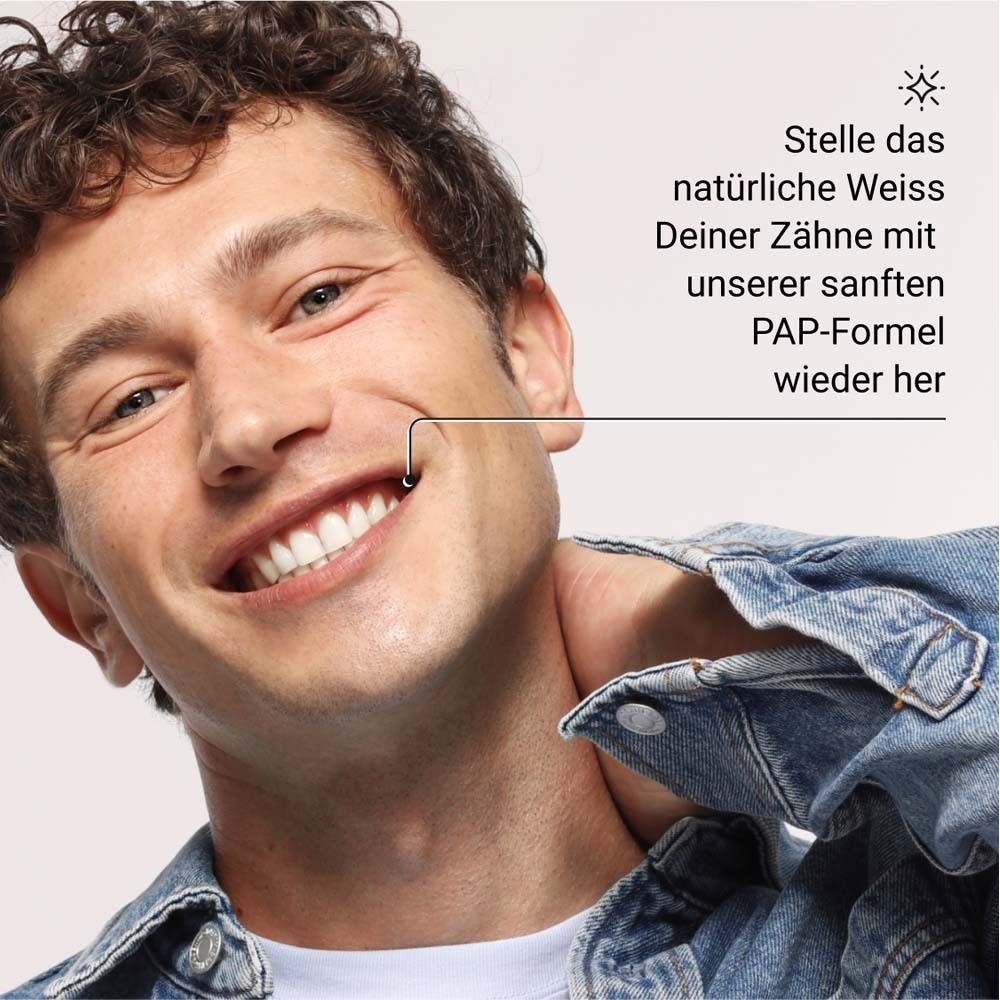 Mann lächelt. Text: Stelle das natürliche Weiß Deiner Zähne mit unserer sanften PAP-Formel wieder her.