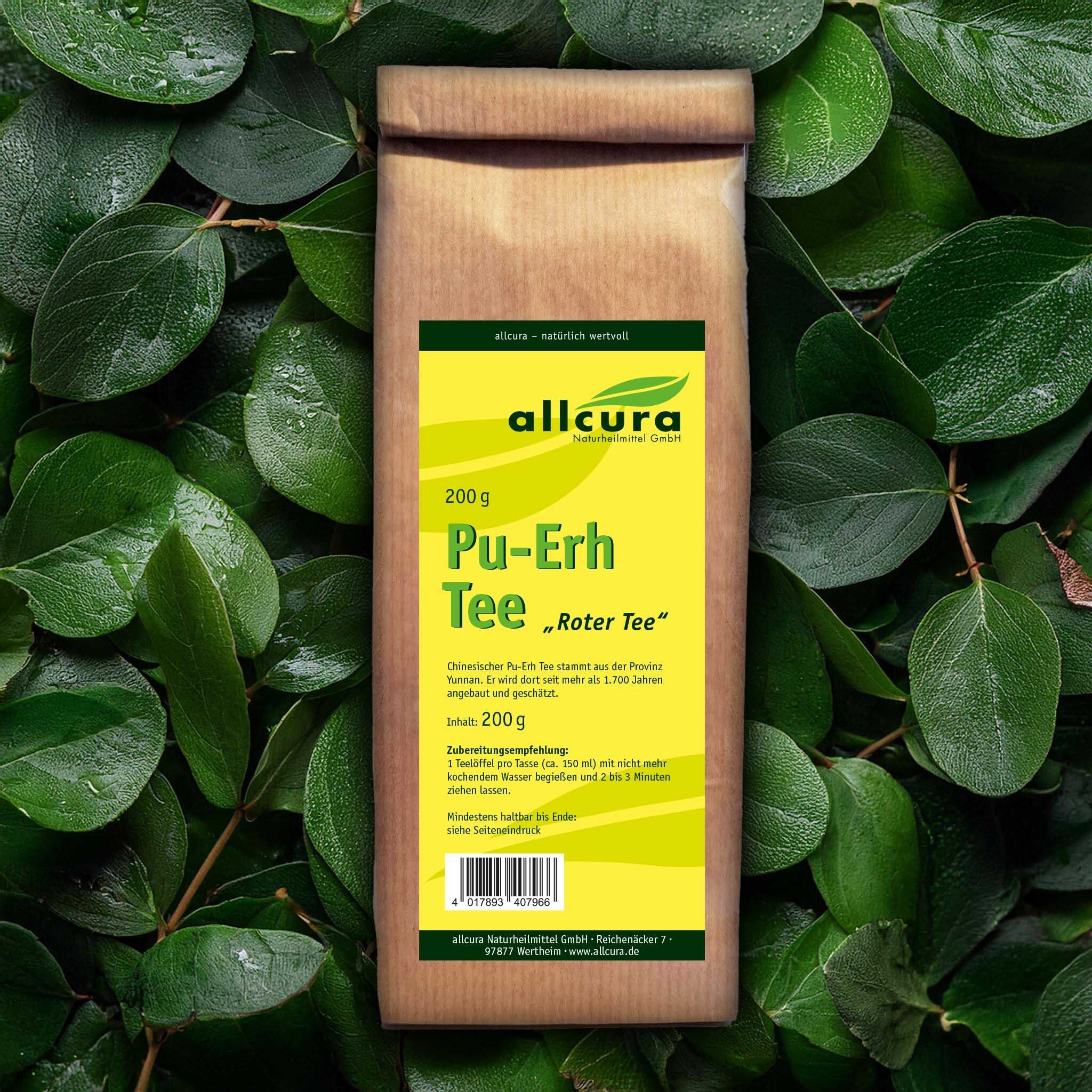 Braune Papiertüte mit grünem Etikett, umgeben von grünen Blättern. Auf dem Etikett steht "allcura Pu-Erh Tee Roter Tee" und "200 g".