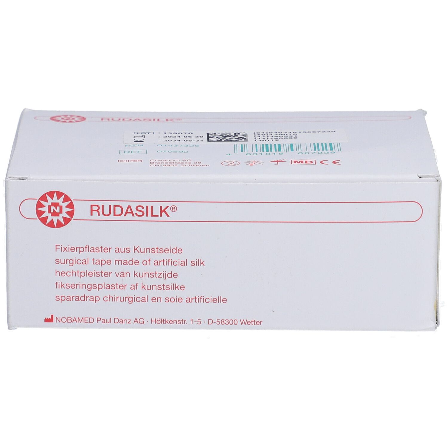 Weiße Verpackung mit rotem RUDASILK Logo. Text: Fixierpflaster aus Kunstseide. Herstelleradresse.