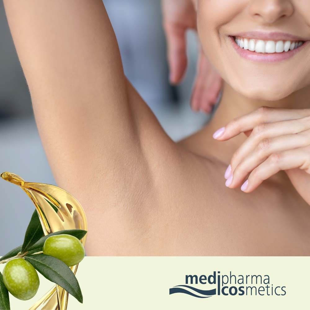 Nahaufnahme einer Achselhöhle. Olivenzweig und Olivenöl daneben. Marke: medipharma cosmetics.