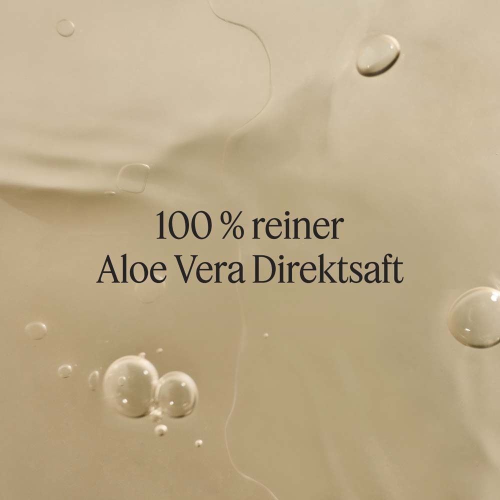 Nahaufnahme von Flüssigkeit mit Blasen. Text: 100 % reiner Aloe Vera Direktsaft.