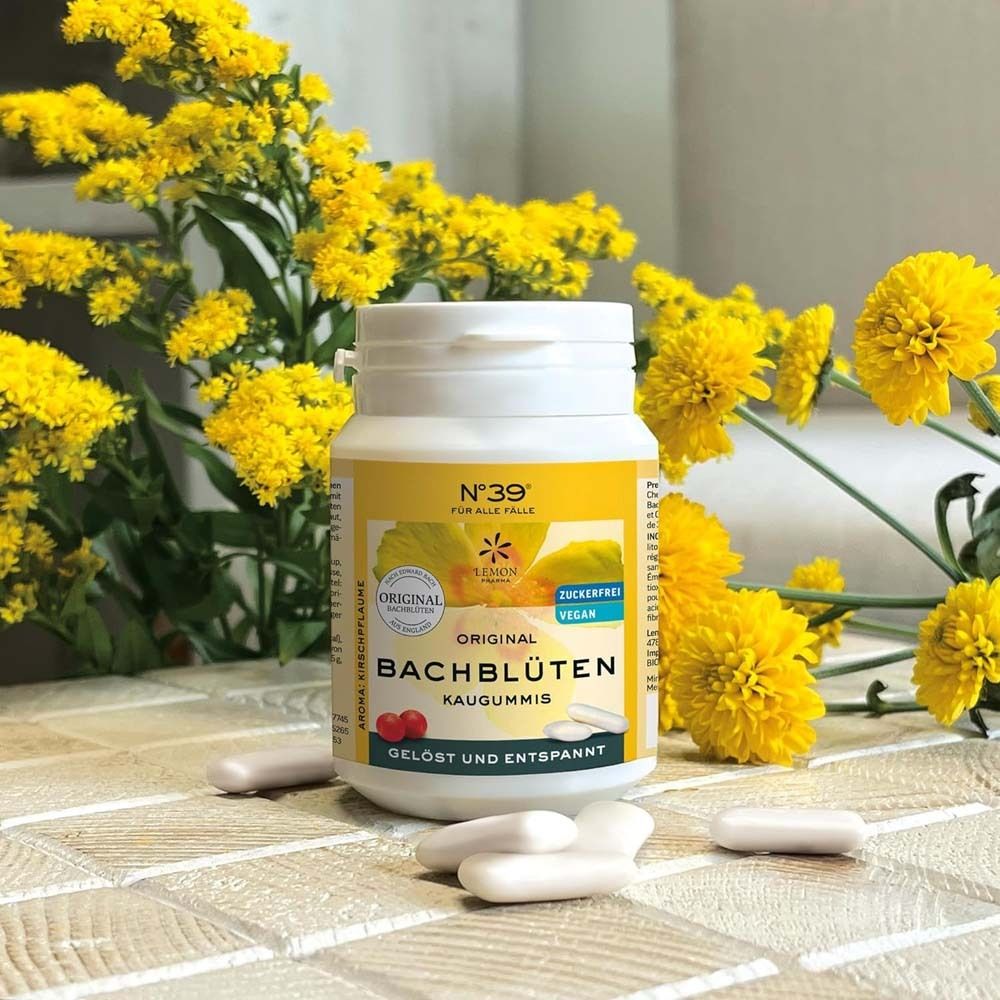 Weiße Dose mit gelbem Etikett, Original Bachblüten Kaugummis. Gelbe Blumen im Hintergrund. Kaugummis liegen daneben.
