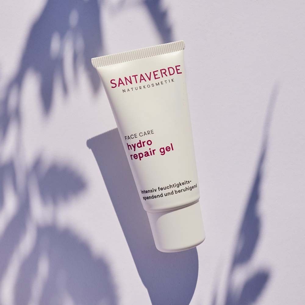 Weiße Tube mit SANTAVERDE-Logo und Produktbezeichnung. Schatten von Blättern im Hintergrund.