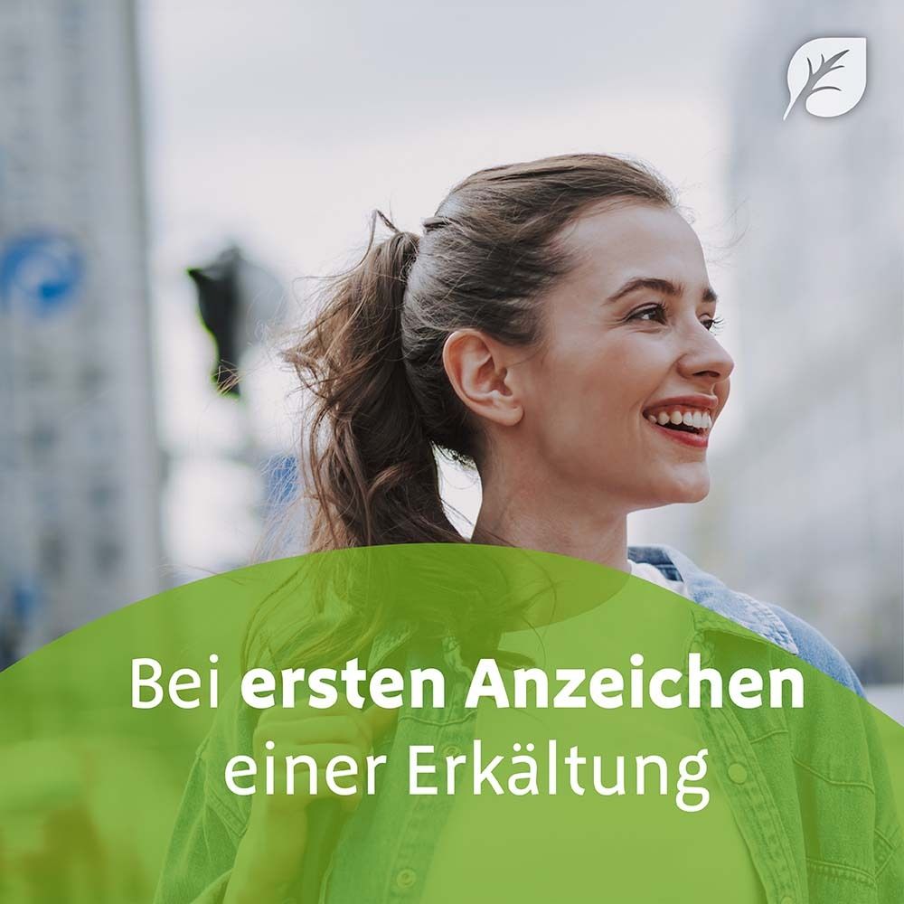 Frau lächelt. Text: Bei ersten Anzeichen einer Erkältung. Grüner Hintergrund mit Blatt-Logo.