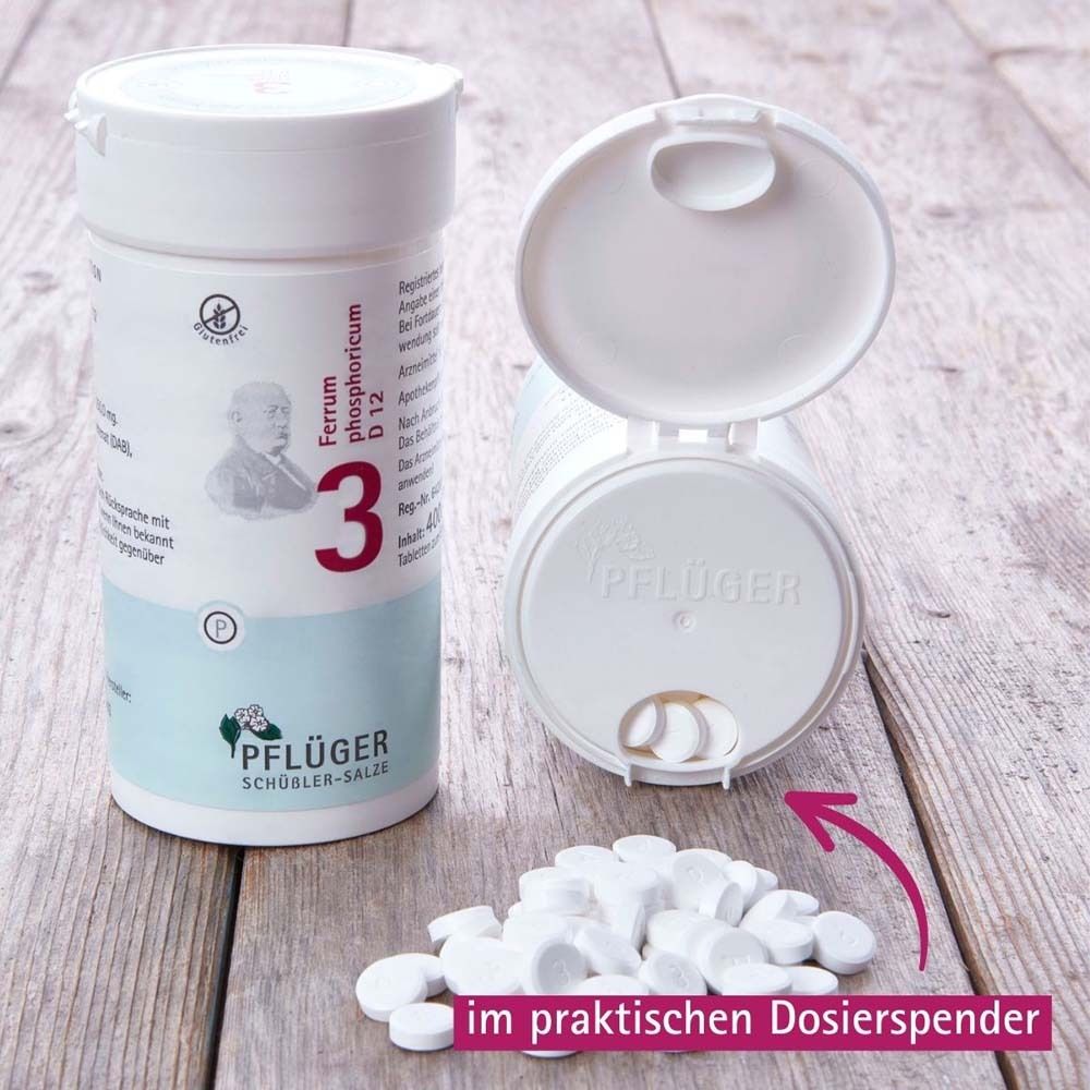 Weiße Tabletten aus einer geöffneten Dose. Aufdruck: 3, Ferrum phosphoricum D12. Tabletten im praktischen Dosierspender.
