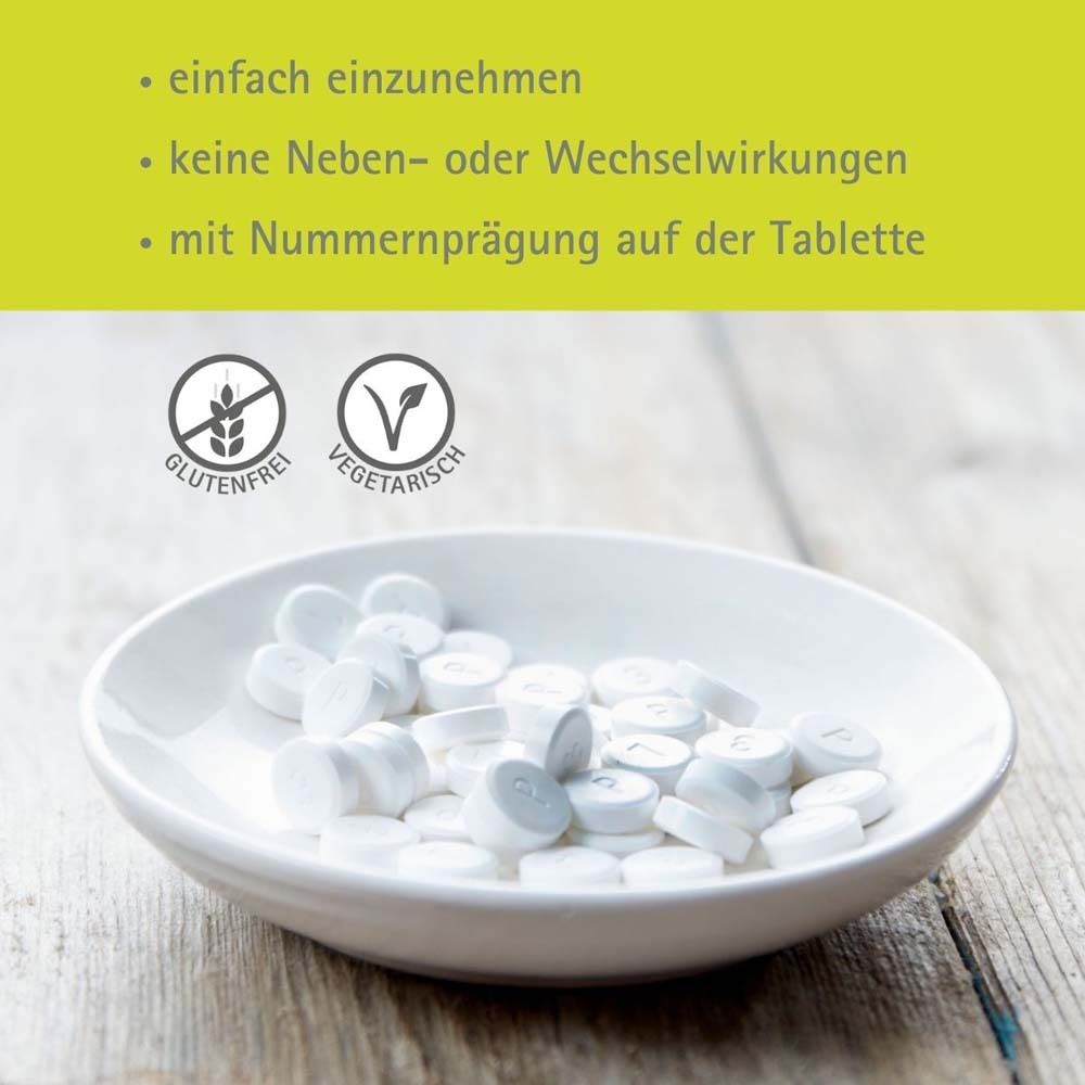 Weiße Tabletten in einer Schale. Text: Glutenfrei, Vegetarisch. Text: mit Nummernpraegung auf der Tablette.