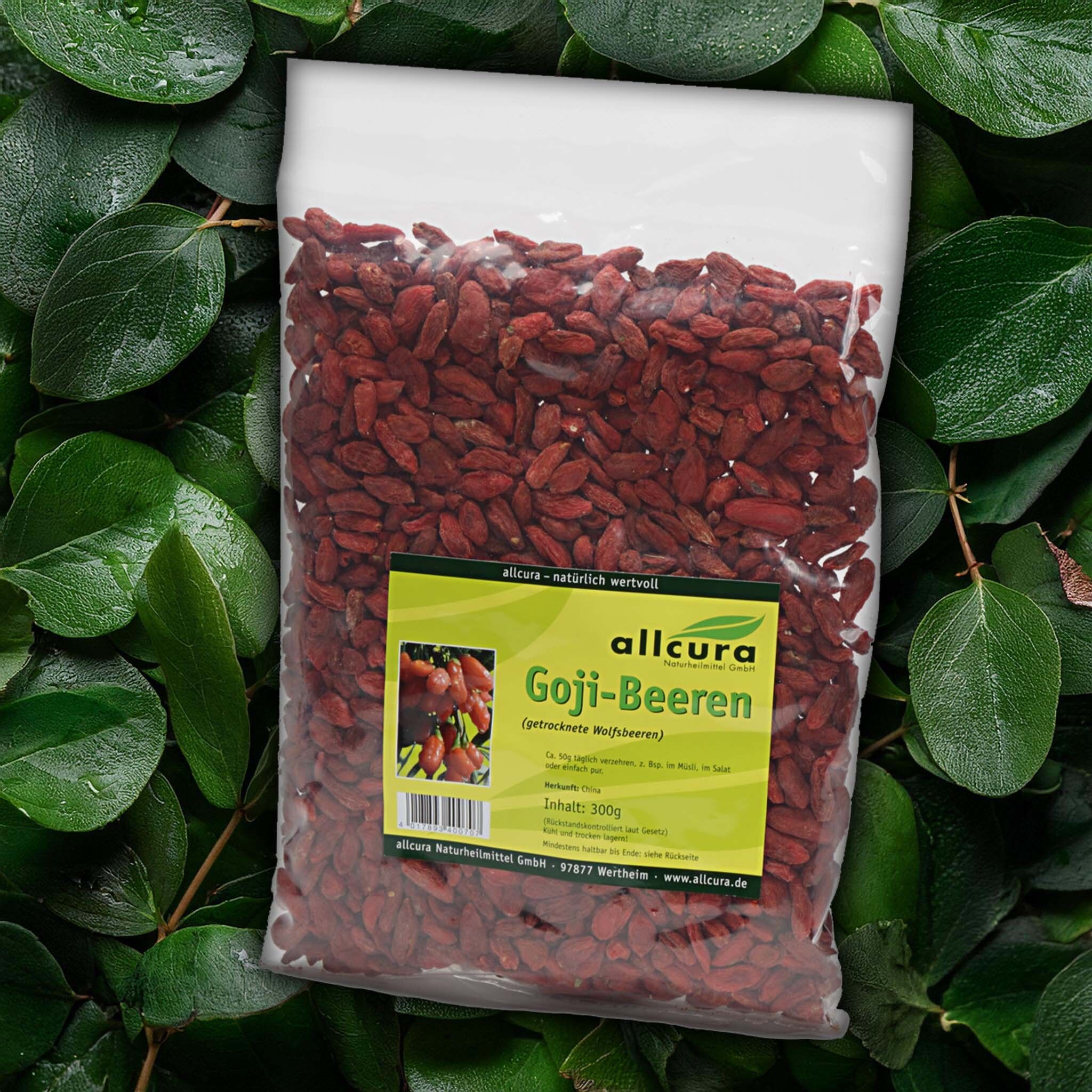 Gojibeeren in transparenter Verpackung, umgeben von Blättern. Aufkleber mit Produktname und Logo.