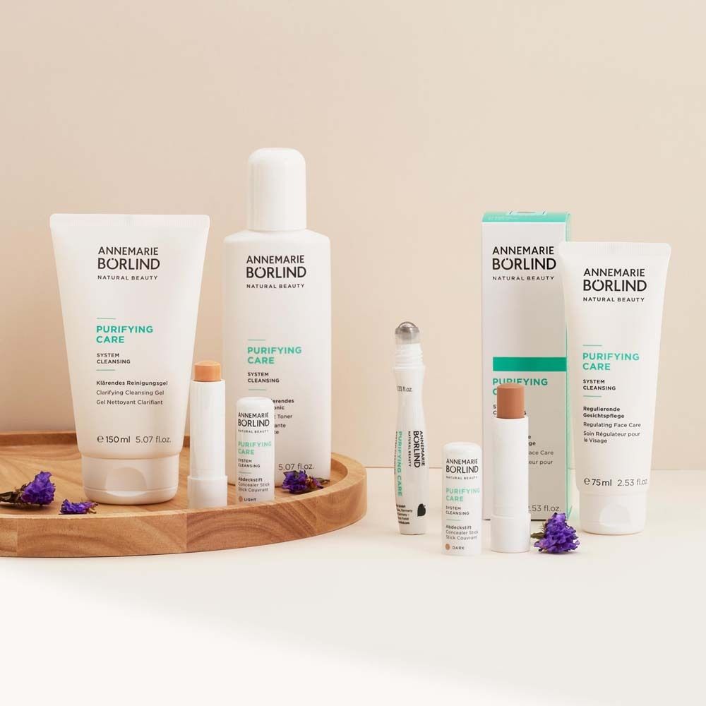 Verschiedene Kosmetikprodukte auf Holztablett. Marke: ANNEMARIE BÖRLIND. Produkte: Reinigungsgel, Lippenbalsam, Augenroller, etc.