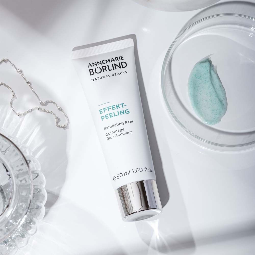 Weiße Tube EFFEKT-PEELING von ANNEMARIE BÖRLIND neben Glasgefäß mit Peeling-Textur.