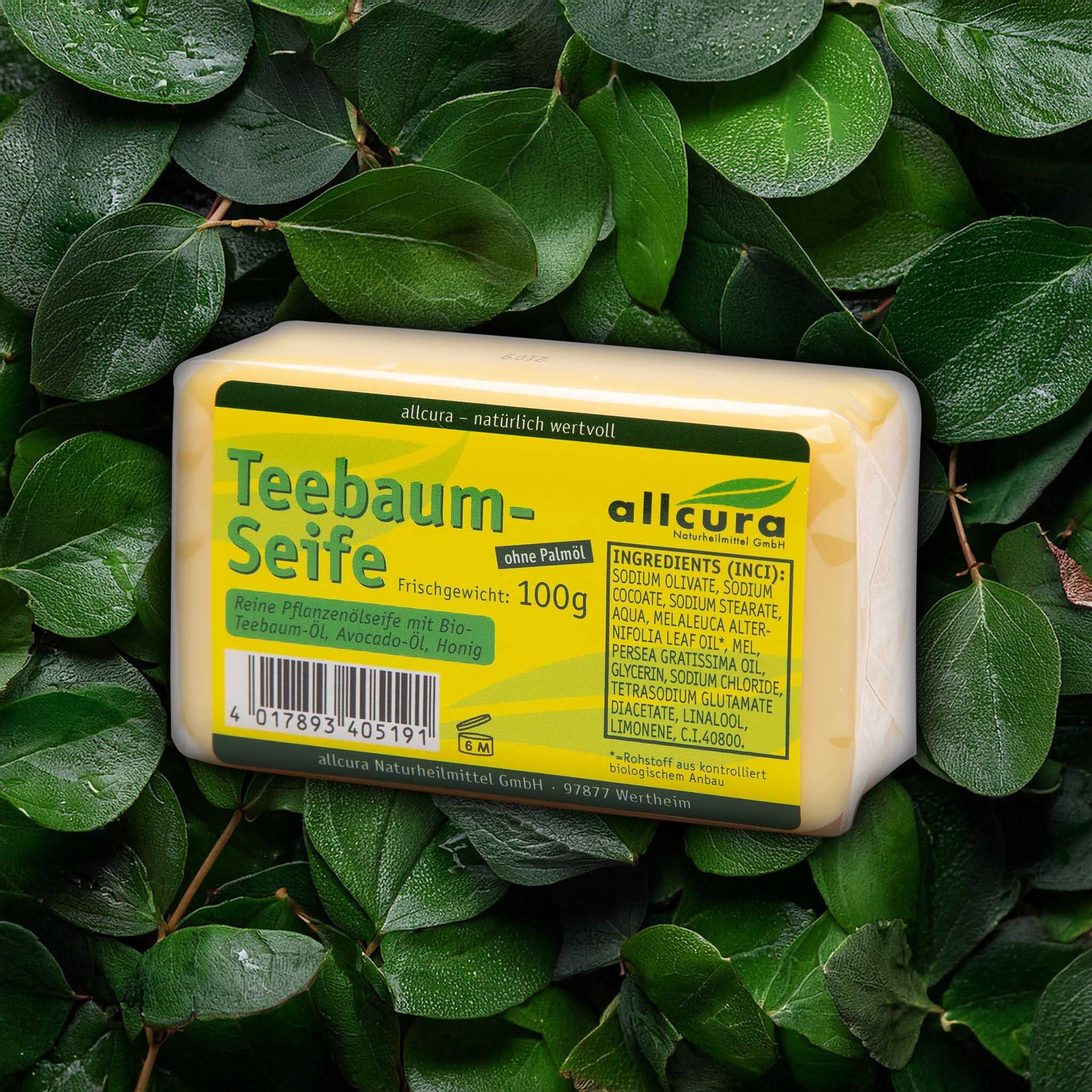Gelbe Seife auf Blättern. Aufschrift: Teebaum-Seife, allcura. Gewicht 100g. Inhaltsstoffe.