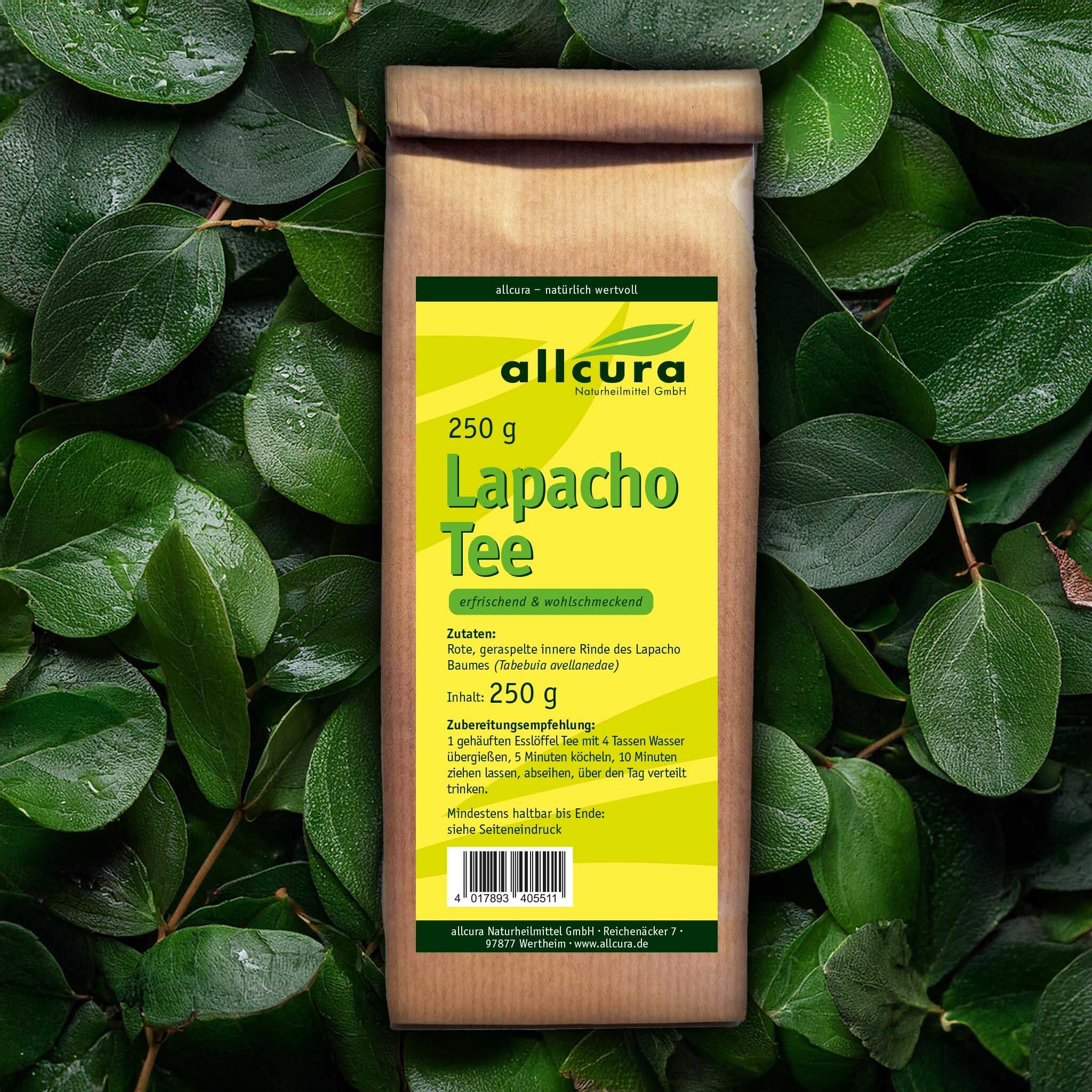 Braune Papiertüte mit gelbem Etikett, umgeben von grünen Blättern. Aufschrift: allcura, Lapacho Tee, 250 g.