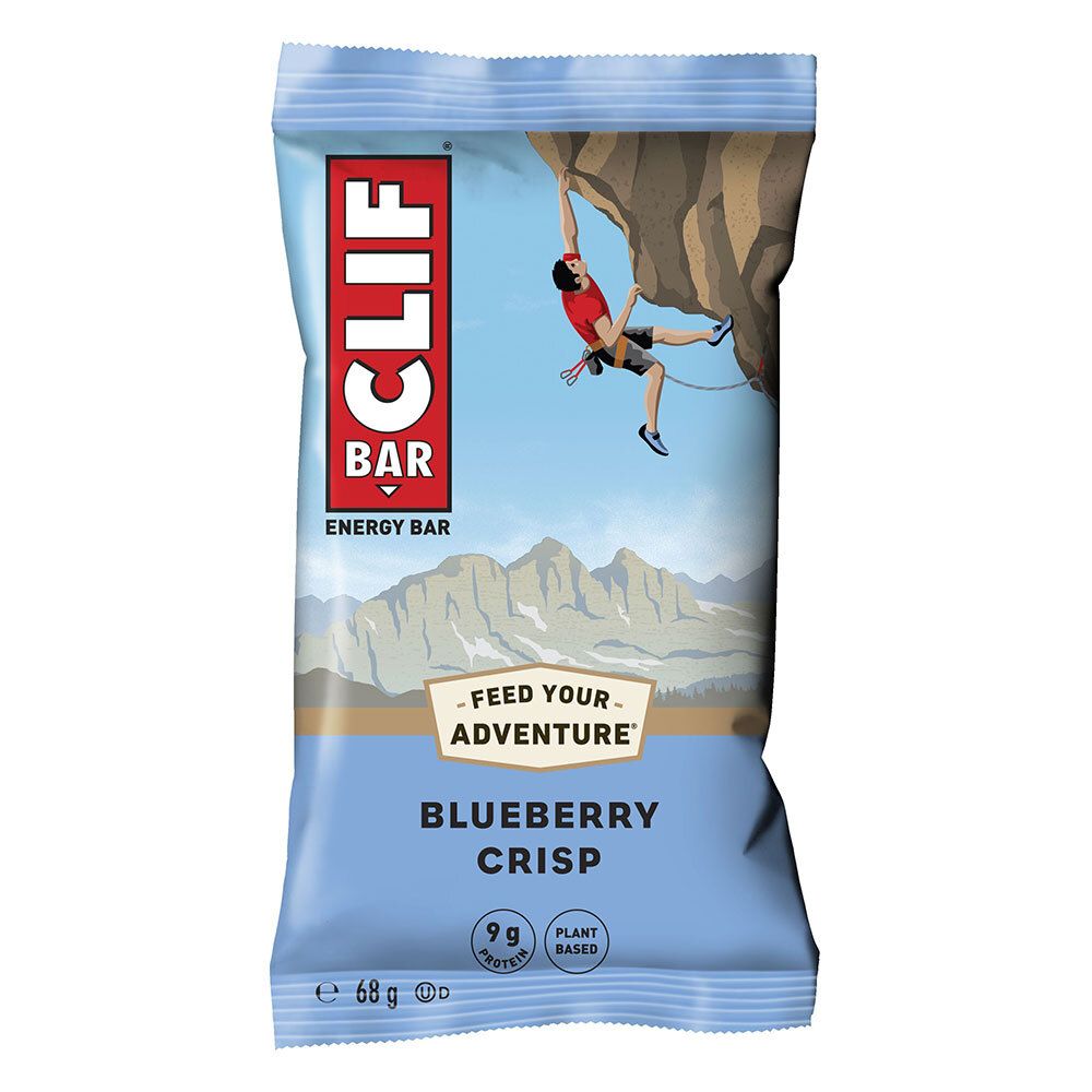 Verpackung eines CLIF BAR Blueberry Crisp Riegels. Blauer Hintergrund mit Kletterer. Text: CLIF BAR, Blueberry Crisp, 9g Protein.