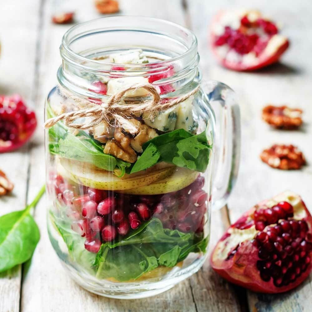 Salat im Glas mit Blattsalat, Birne, Walnüssen und Granatapfelkernen.