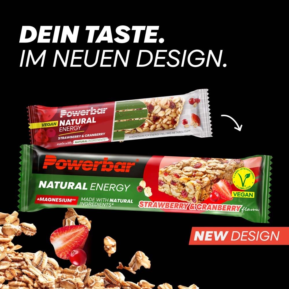 Zwei PowerBar Natural Energy Riegel, Erdbeer-Cranberry. Schwarzer Hintergrund. Vegan. Neues Design. Riegel und Zutaten abgebildet.