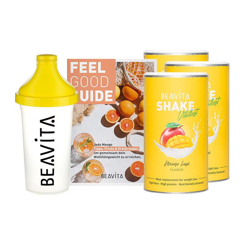 Diät-Paket mit Shaker, Broschüre und Dosen. Gelbe und weiße Elemente. Aufschrift BEAVITA. Auf den Dosen: Shake Vitalboost, Mango Lassi.