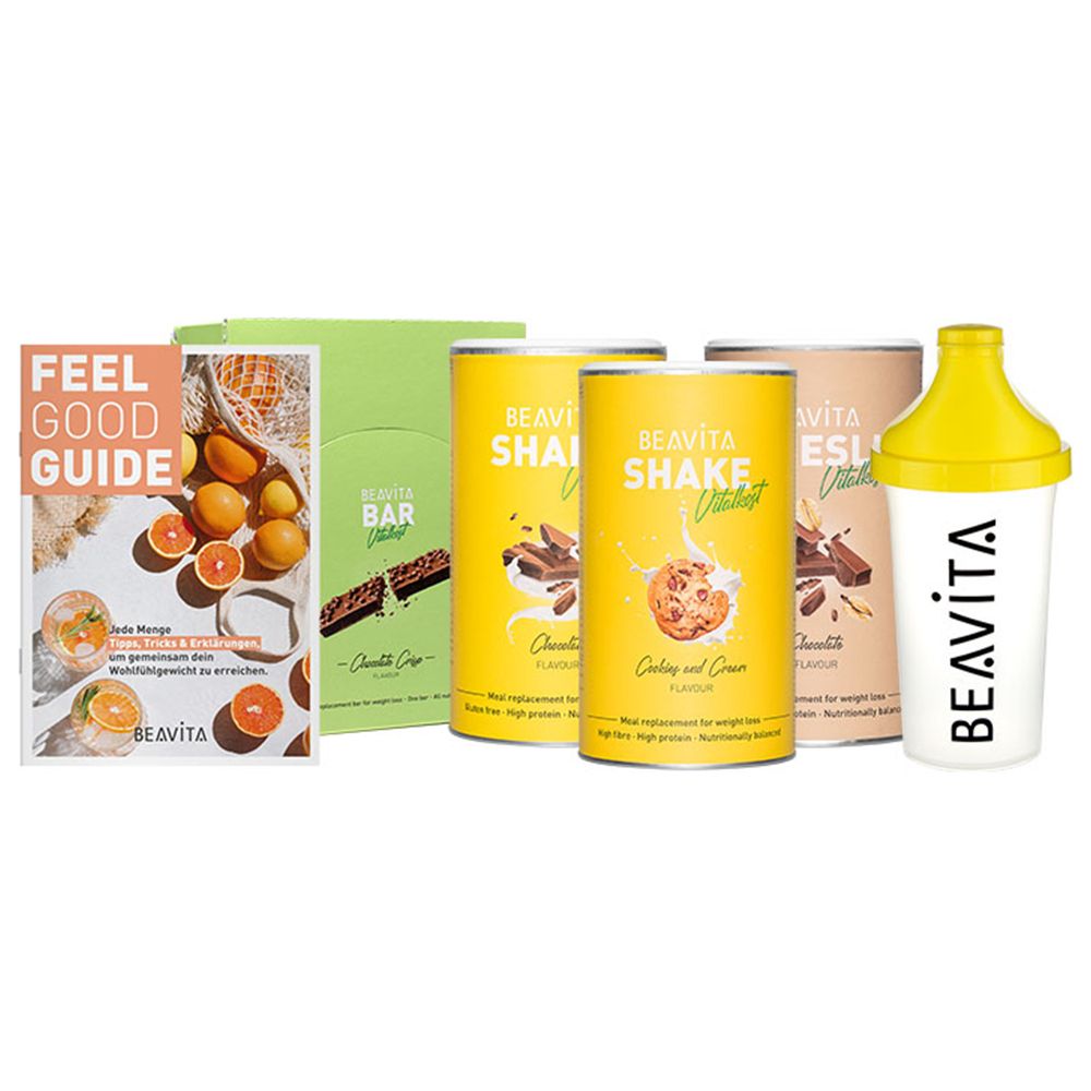 Diät-Set mit Shakes, Riegeln, und einem Shaker. Aufdrucke: BEAVITA, Shake, Bar, Feel Good Guide. Gelbe, grüne, braune und weiße Verpackungen.