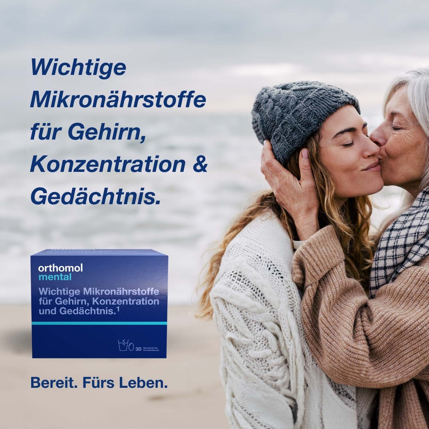 Frau küsst Frau. Im Hintergrund: Orthomol mental-Packung. Text: Wichtige Mikronährstoffe für Gehirn, Konzentration & Gedächtnis.