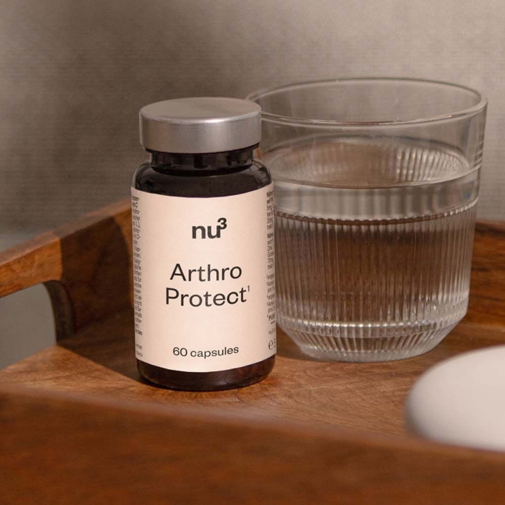 Braune Flasche mit Etikett. Aufschrift: nu3 Arthro Protect, 60 Kapseln. Neben der Flasche: Glas Wasser.