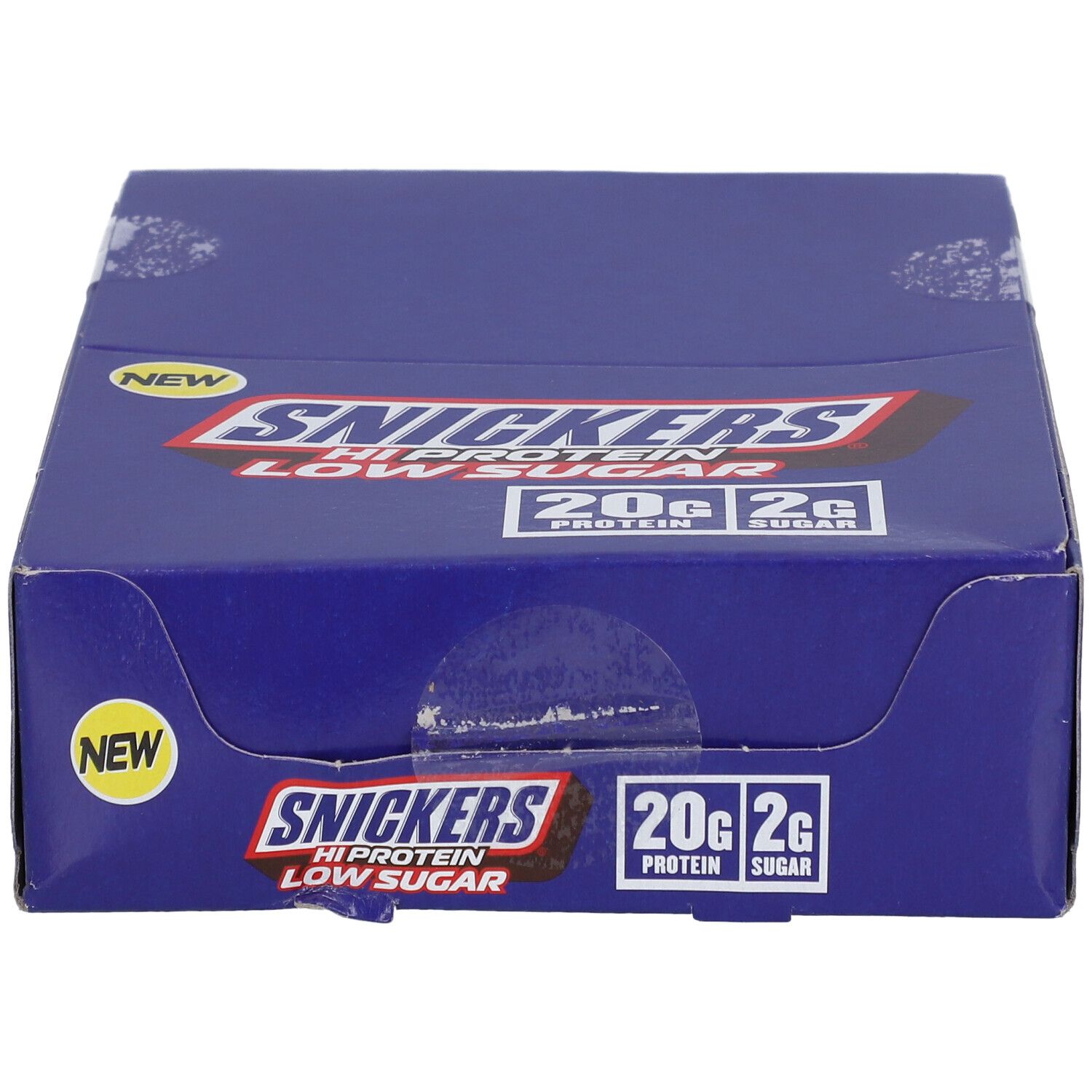 Blauer Karton mit SNICKERS HiProtein Low Sugar. Aufschrift: 20g Protein, 2g Zucker. Mit „NEW“ Aufkleber.
