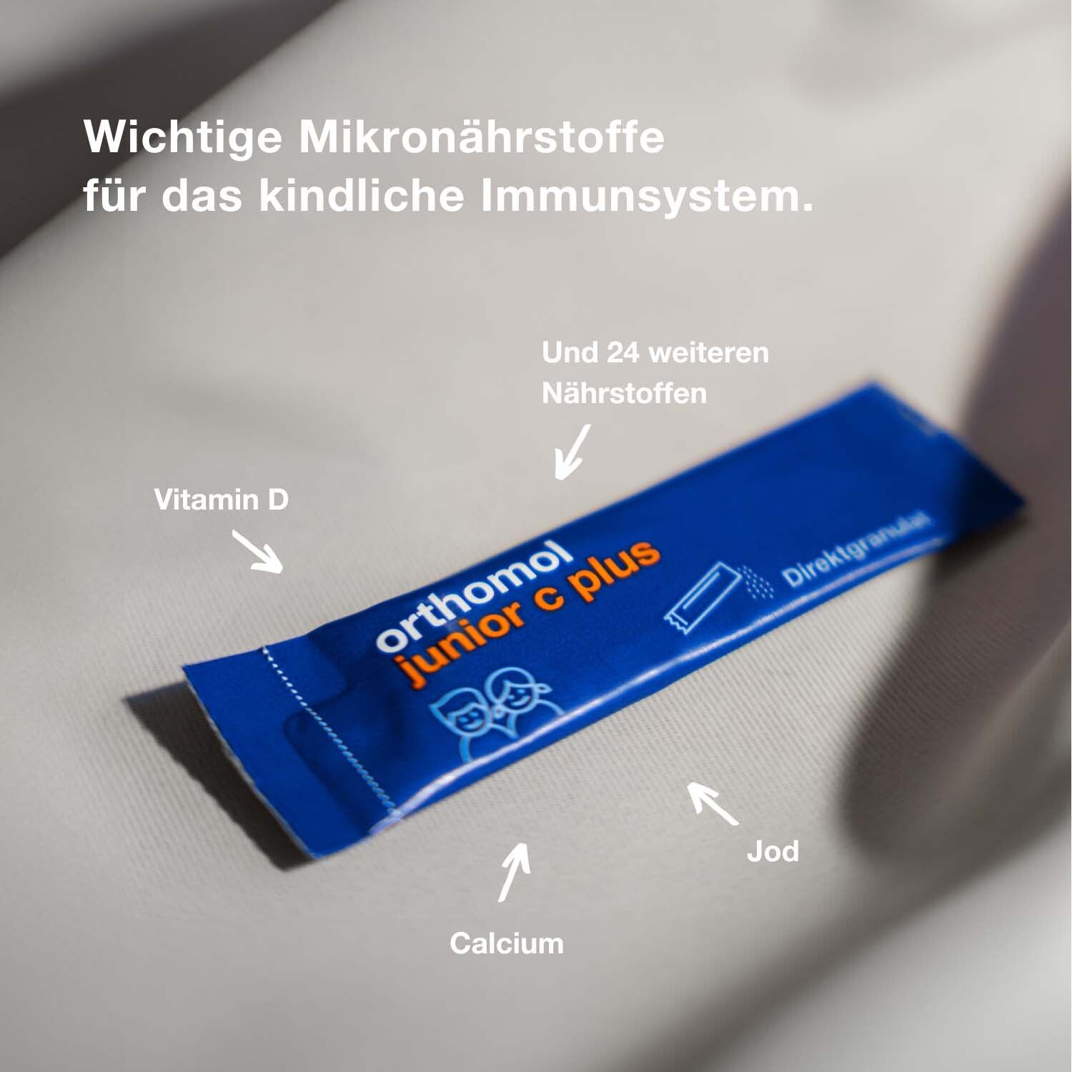Blauer Beutel Orthomol junior c plus. Pfeile zeigen auf Vitamin D, Calcium und Jod. Direktgranulat.