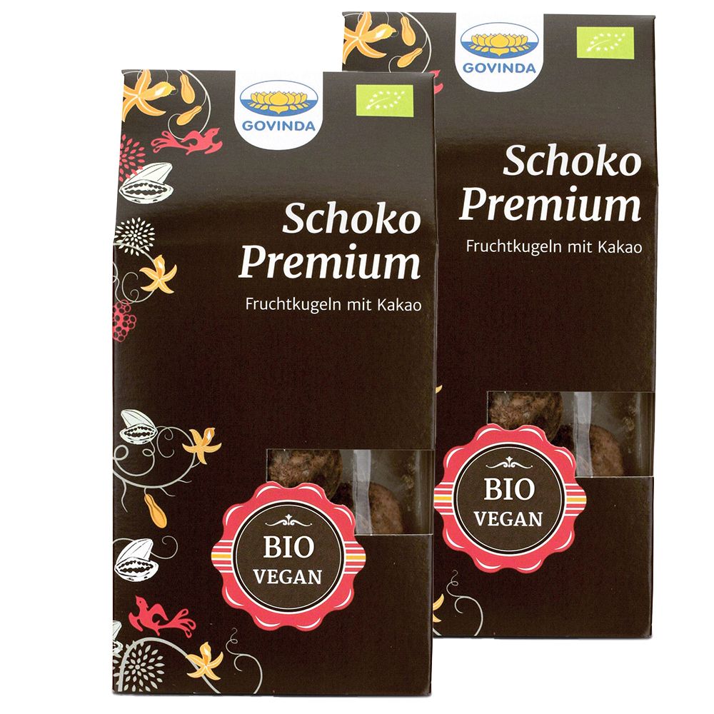 Zwei Schachteln mit Schoko Premium Fruchtkugeln. Aufdrucke: Govinda, Bio, Vegan. Sichtfenster zeigen Kugeln.