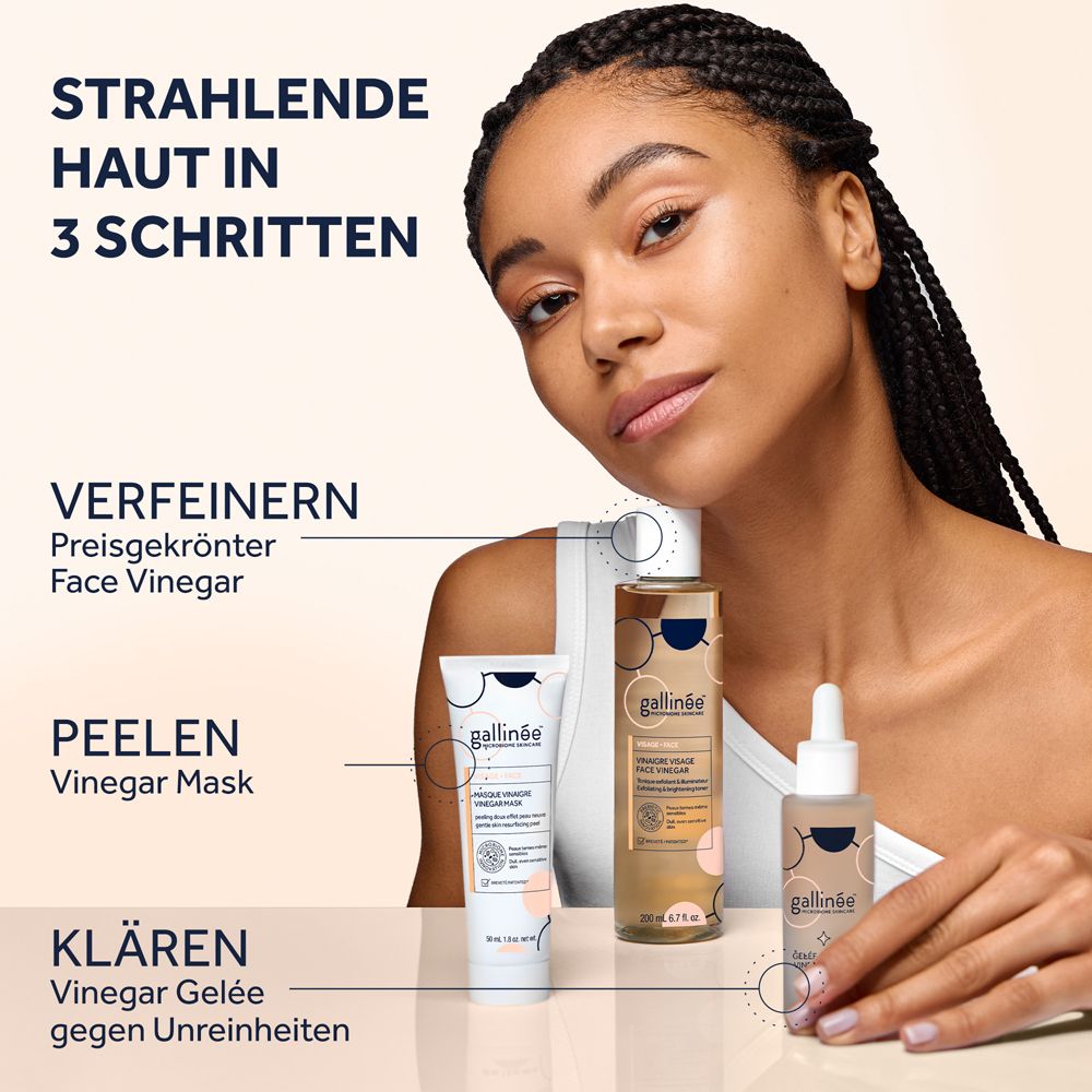 Eine Frau mit geflochtenen Haaren präsentiert drei Hautpflegeprodukte: eine Maske, eine Lotion und ein Serum.