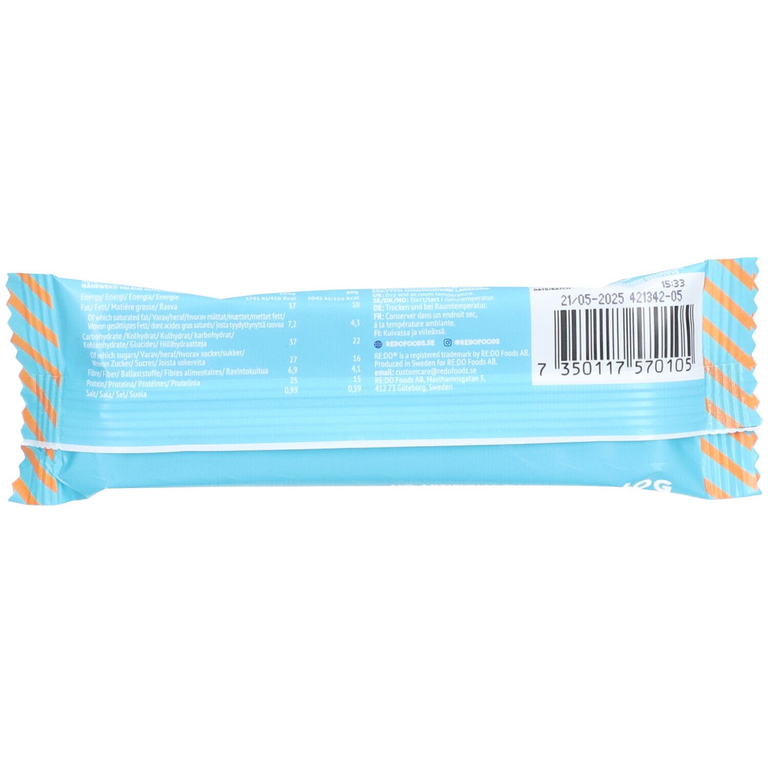 Rückseite des Riegels in hellblauer Verpackung. Enthält Nährwertangaben und einen Barcode. Gestreiftes Design an den Rändern.