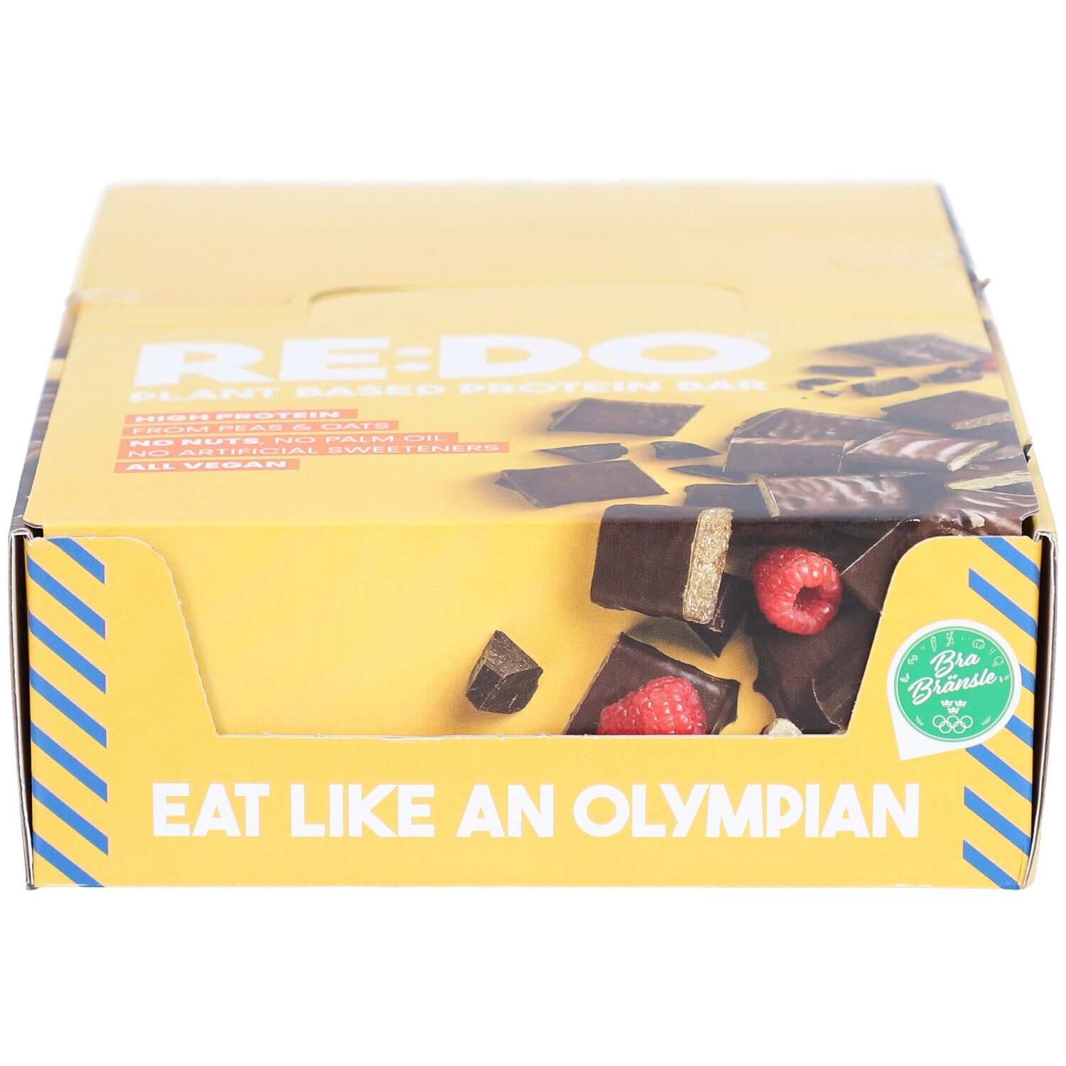 Gelbe Kartonverpackung mit RE:DO-Logo und Text. Zeigt Riegel mit Himbeeren. Aufschrift: Eat like an Olympian. Bio-Siegel.
