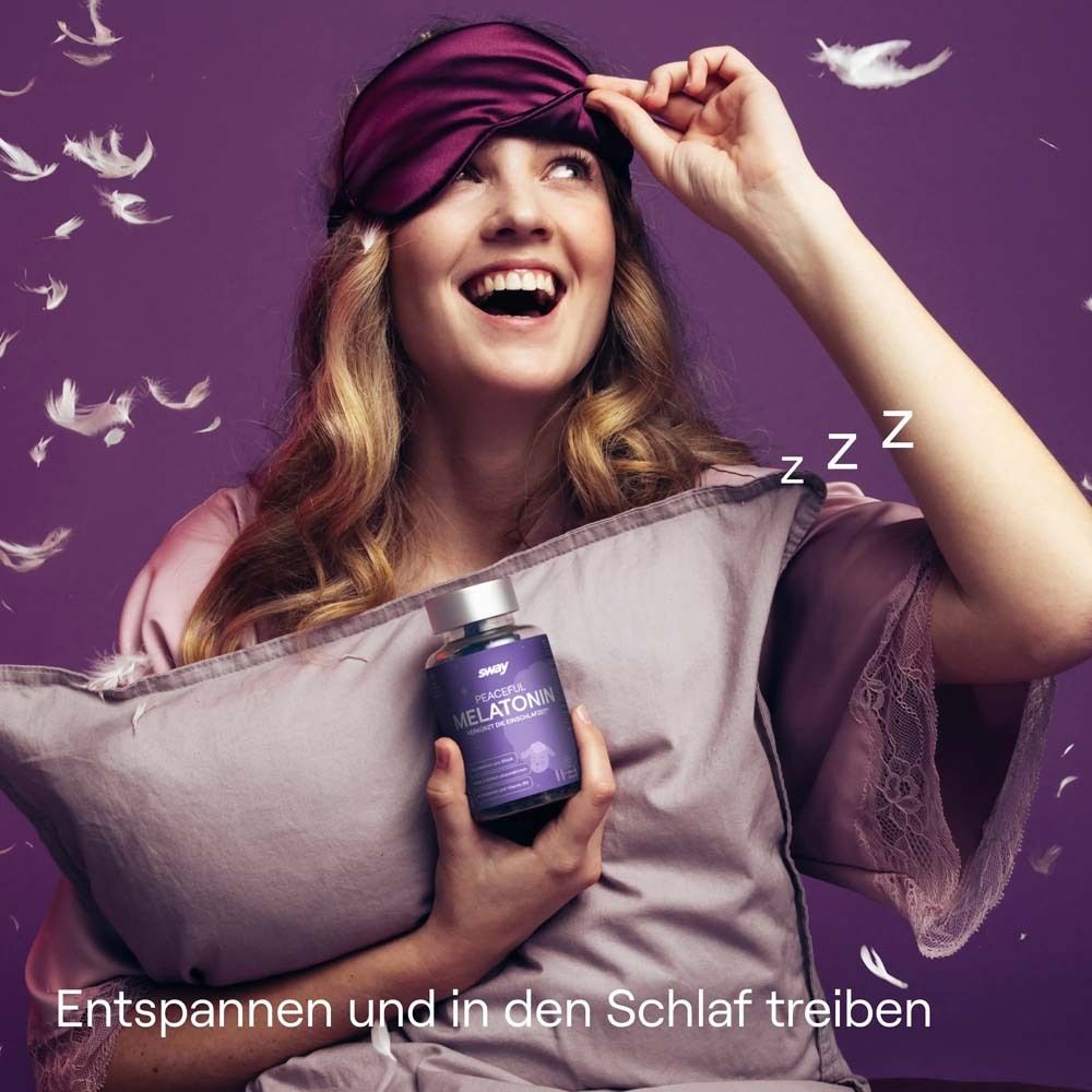 Frau mit Schlafmaske und Kissen. Hält eine Flasche. Hintergrund mit Federn.