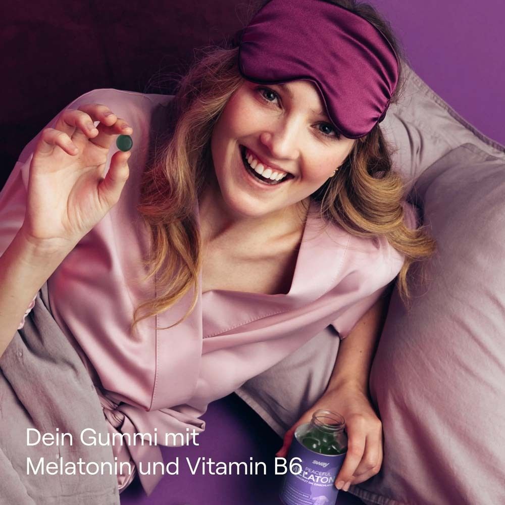 Frau mit Schlafmaske hält ein Gummibärchen und eine Flasche. Hintergrund lila.