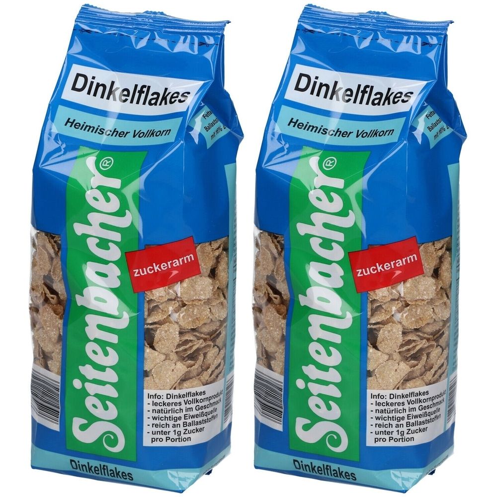 Zwei Beutel Dinkelflakes. Blaue Verpackung mit Produktnamen und Marke Seitenbacher. Rotes Etikett mit "zuckerarm".
